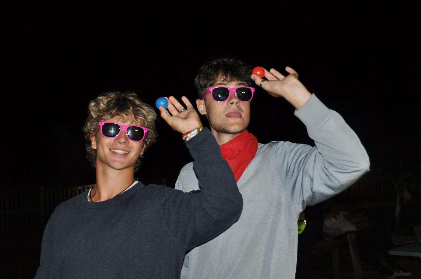 Deux étudiants en lunettes roses posant de nuit