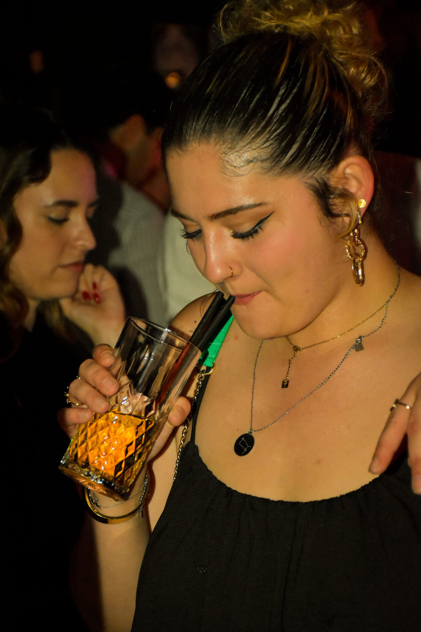 Invitée buvant un verre au milieu du public