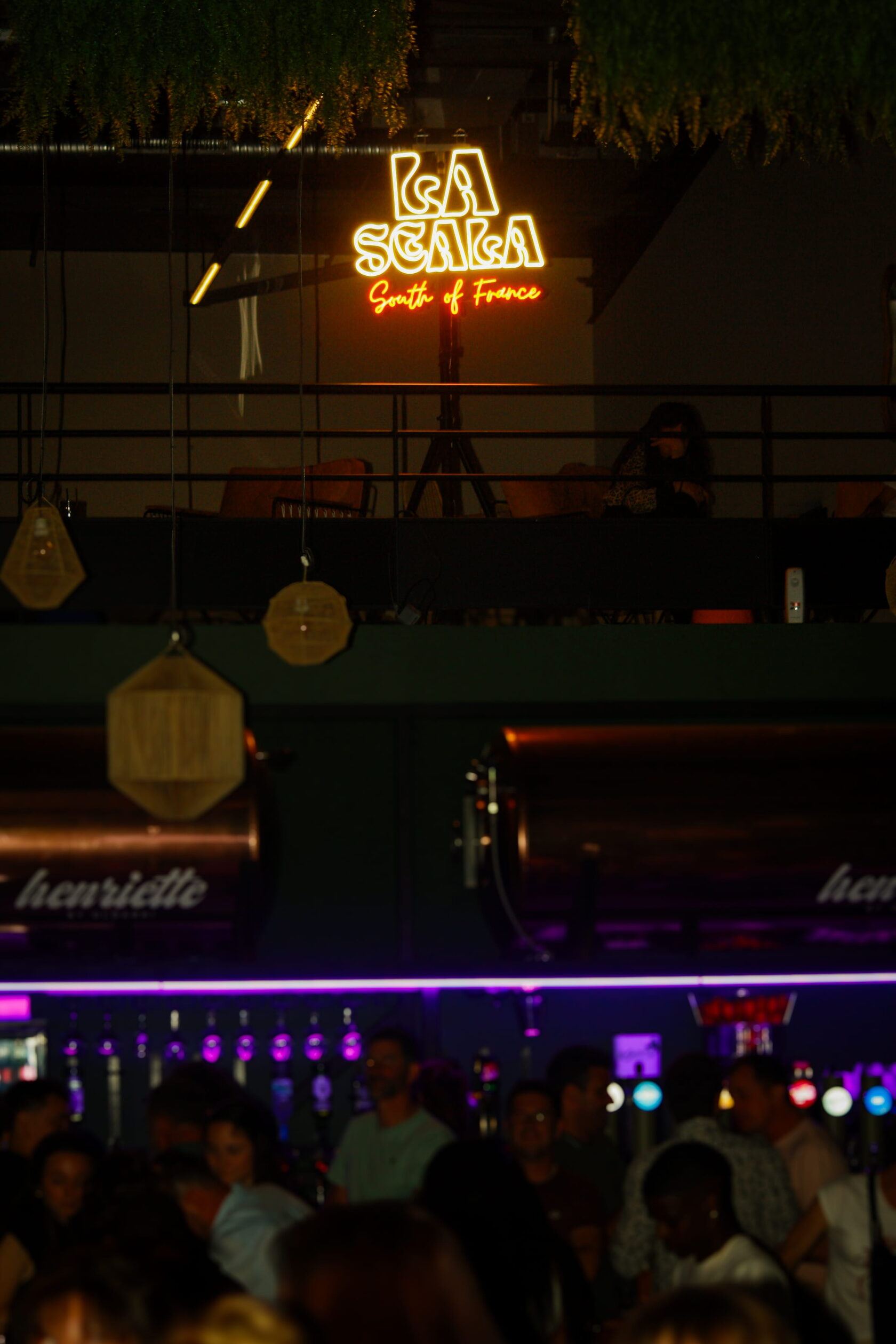 Enseigne La Scala au-dessus du bar éclairé et du public