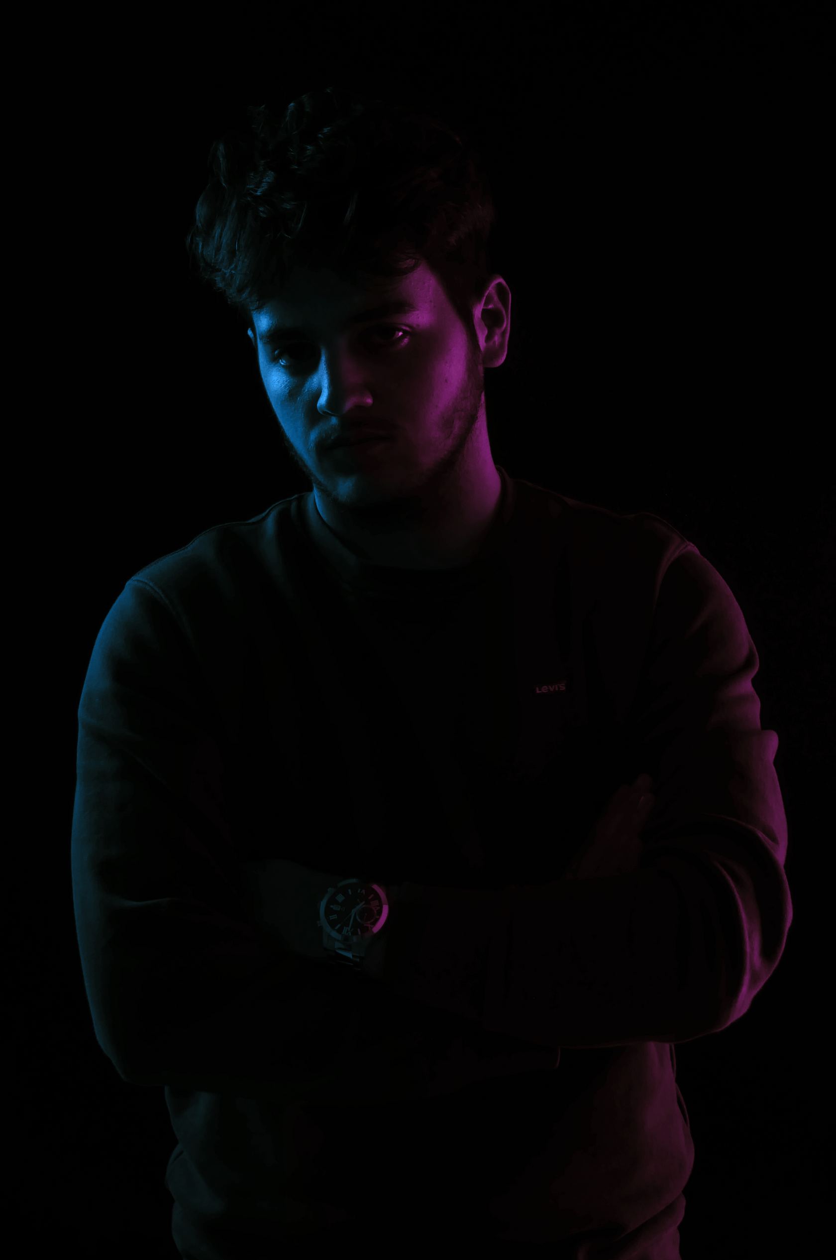 Portrait d’un homme dans l’ombre, éclairé de deux lumières colorées